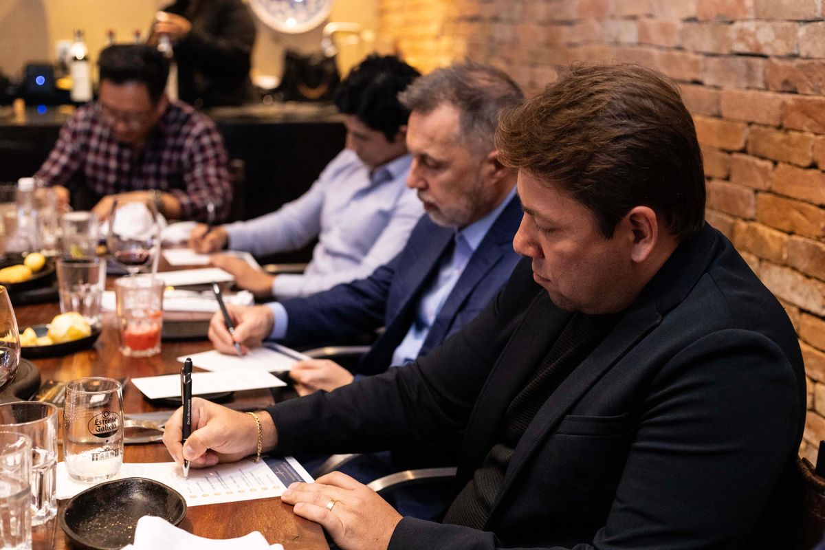 Participantes escrevendo durante uma atividade na mesa