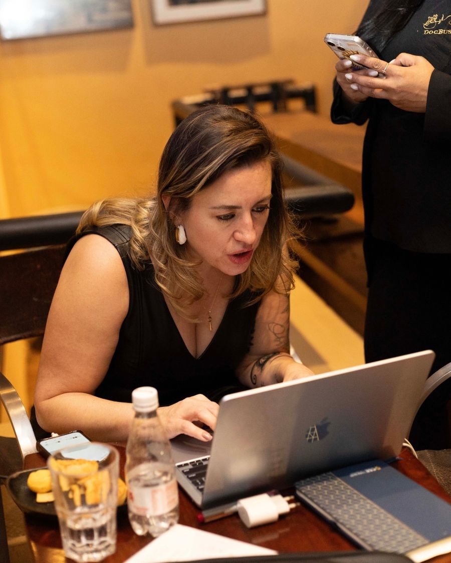 Luciane Macieira trabalhando em um notebook durante um atendimento